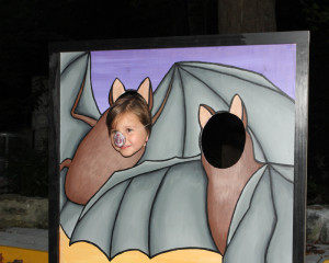 A photo of a child in a bat cutout photo op